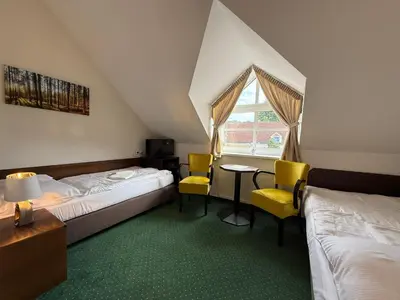 a hotel room with two beds and a table and chairs at Bechnerův statek in Lány
