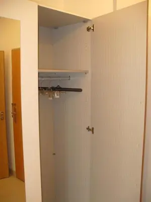 a closet with white walls and a door with a mirror at Garden apartment with garage in central Prague in Prague