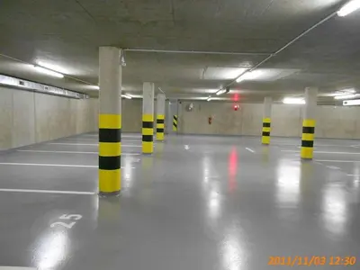 an empty parking garage with yellow and black poles at Garden apartment with garage in central Prague in Prague