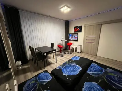 a bedroom with a bed and a table with blue roses at MONFas APARTMENT BARRANDOV in Prague