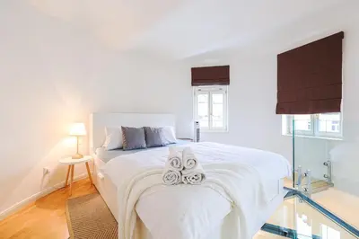a white bedroom with a bed with two towels on it at Stevan Apartment in Prague