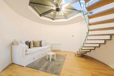 a living room with a white couch and a staircase at Stevan Apartment in Prague