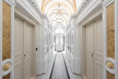 a hallway with white walls and a ceiling with a chandelier at Stevan Apartment in Prague