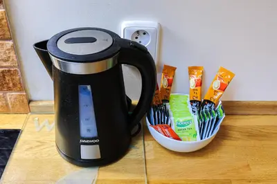a black coffee maker is next to a cup of toothbrushes at Stevan Apartment in Prague