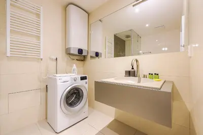 a bathroom with a washing machine and a sink at Stevan Apartment in Prague