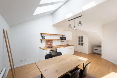 a kitchen and dining room with a wooden table at Stevan Apartment in Prague