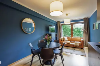 a living room with blue walls and a table and chairs at Apartmány Mind Adventure in Lštění