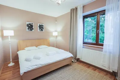 a bedroom with a bed with white sheets and a window at Apartmány Mind Adventure in Lštění