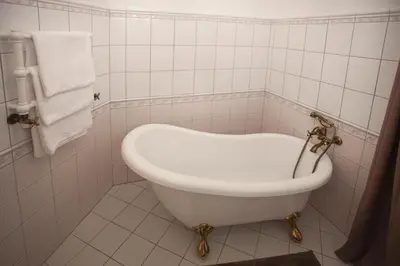 a bath tub in a bathroom with white tiles at Apartmány Mind Adventure in Lštění