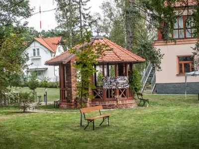 a gazebo in a yard with a bench at Hotel U Parku in Hořovice