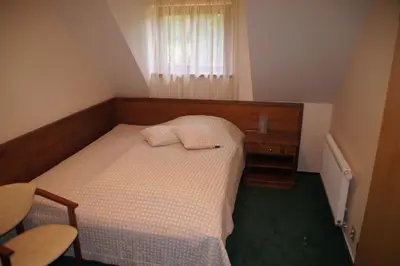 a small bedroom with a bed and a window at Hotel U Parku in Hořovice