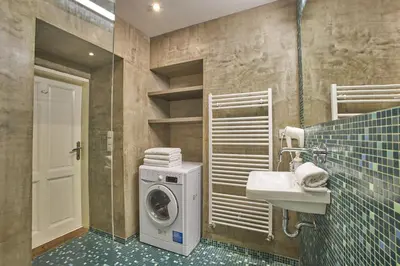 a bathroom with a washing machine and a sink at Jeruzalémská - Synagogue Apartments in Prague