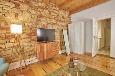 a living room with a tv and a brick wall at Jeruzalémská - Synagogue Apartments in Prague