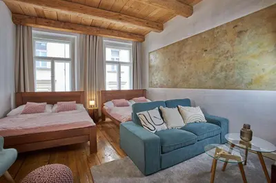 a living room with a blue couch and a bed at Jeruzalémská - Synagogue Apartments in Prague