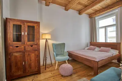 a bedroom with a bed and a chair and a window at Jeruzalémská - Synagogue Apartments in Prague