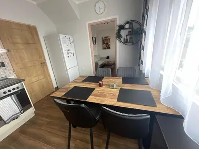 a kitchen with a wooden table and black chairs at Andel apartment with terrace in Prague
