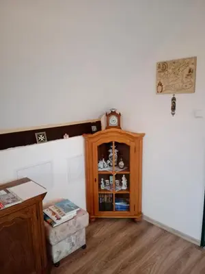 a room with a cabinet and a clock on a wall at Chalupa u dědy in Dlažkovice