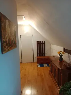 an attic room with a door and a wooden floor at Chalupa u dědy in Dlažkovice