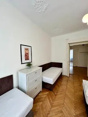 a room with two beds and a dresser in it at Prague Central Exclusive Apartments in Prague