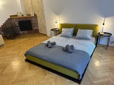 a bedroom with a bed with two pillows and a fireplace at Nerudova Apartments in Prague