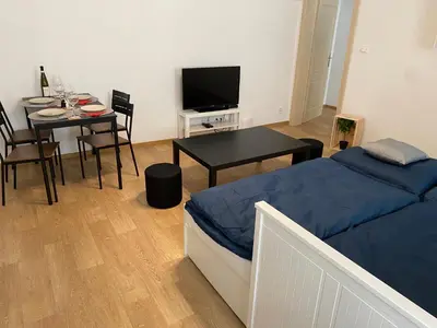 a kitchen with white cabinets and a table in it at Nerudova Apartments in Prague