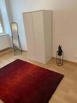 a bedroom with two beds and a table and a television at Nerudova Apartments in Prague