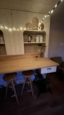 a wooden table with two stools in a room at Glamping - stylová maringotka v srdci Ladova kraje, poblíž hlavního města Prahy in Stříbrná Skalice