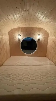 a small room with a circular window in a plane at Glamping - stylová maringotka v srdci Ladova kraje, poblíž hlavního města Prahy in Stříbrná Skalice
