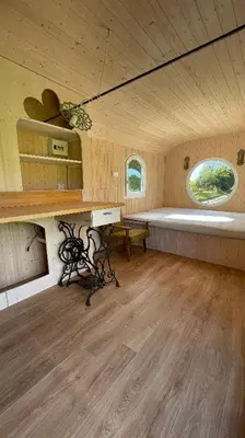 a room with a bench and a table in a cabin at Glamping - stylová maringotka v srdci Ladova kraje, poblíž hlavního města Prahy in Stříbrná Skalice