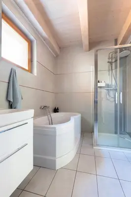 a bathroom with a tub and a glass shower at Slapy Chata Hrdlička in Čím