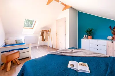 a bedroom with blue walls and a bed with a book at Slapy Chata Hrdlička in Čím