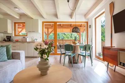 a kitchen and living room with a vase of flowers on a table at Slapy Chata Hrdlička in Čím