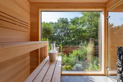 a window seat in a tiny house looking out at a garden at Slapy Chata Hrdlička in Čím