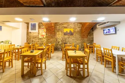 a restaurant with wooden tables and chairs and a tv at Minimino hotel in Prague