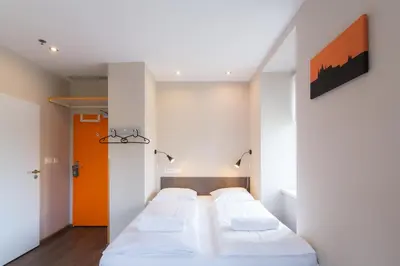 a bedroom with two beds and an orange door at Minimino hotel in Prague