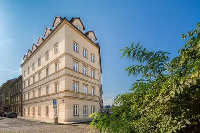 a tall tan building with a pointed roof at Minimino hotel in Prague