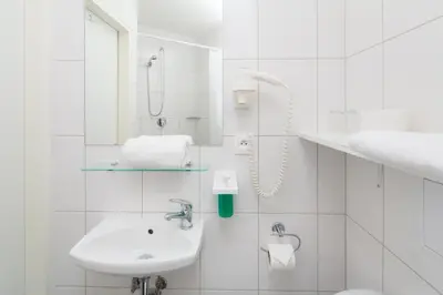 a white bathroom with a sink and a shower at Minimino hotel in Prague