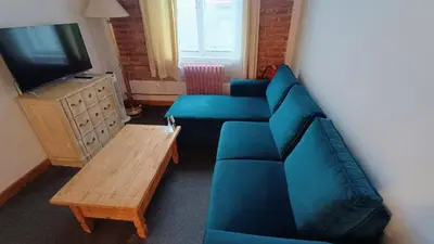 a living room with a blue couch and a tv at S42 Hotel Prague in Prague