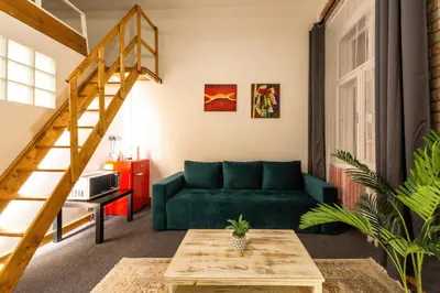 a living room with a green couch and stairs at S42 Hotel Prague in Prague