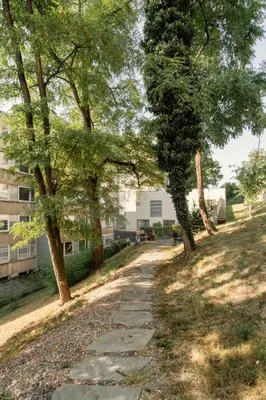 a path in a park with trees and a building at Prague Days - Premium Studios w Stunning Terraces - Easy City Access in Prague