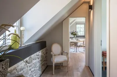 a room with a staircase with a chair and a table at Šťastná Samota in Vrchotovy Janovice