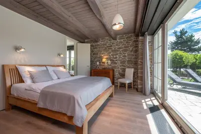 a bedroom with a bed and a stone wall at Šťastná Samota in Vrchotovy Janovice