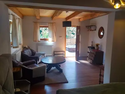a living room with a table and a couch at Stodola-soukromý apartmán pro dva s venkovní vířivkou in Karlštejn