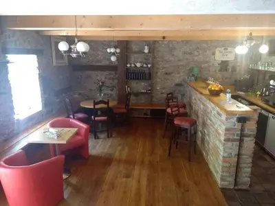 a restaurant with tables and chairs and a bar at Stodola-soukromý apartmán pro dva s venkovní vířivkou in Karlštejn