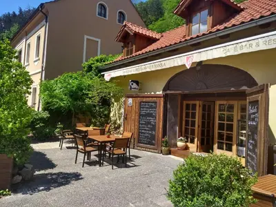 a restaurant with tables and chairs outside of a building at Stodola-soukromý apartmán pro dva s venkovní vířivkou in Karlštejn