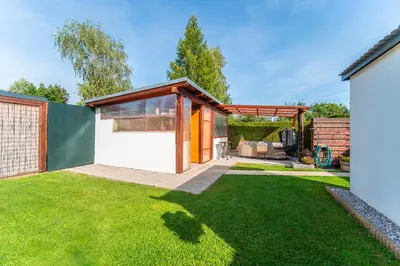 a garden with a house with a green lawn at Holiday House Adonis in Bystřice