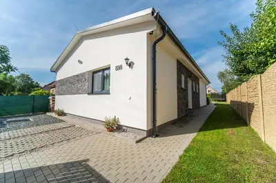 a white house with a door on the side of it at Holiday House Adonis in Bystřice