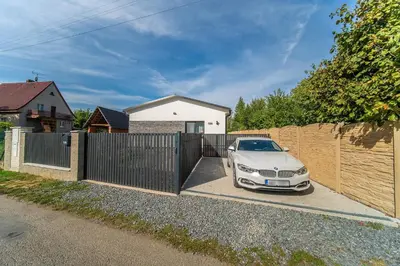 a white car parked in front of a fence at Holiday House Adonis in Bystřice