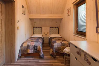 a bedroom with two beds and a table and two windows at RelaxClub Kersko in Hradišťko