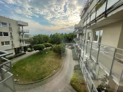a balcony of a building with a view of a park at MONFas APARTMENT PROVENCE IN PRAGUE in Prague